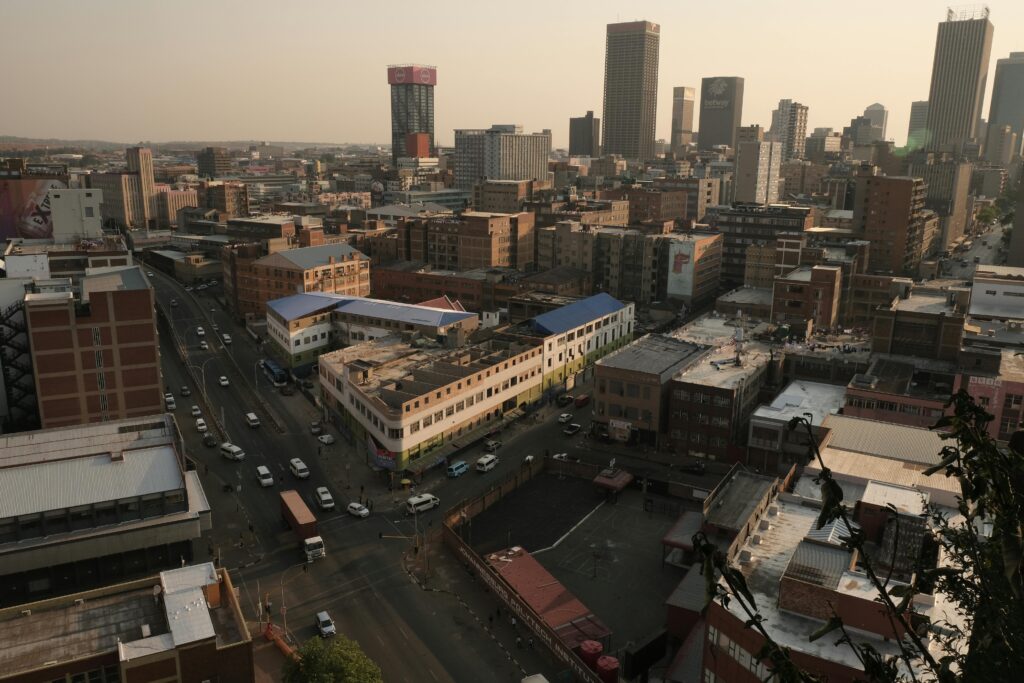 pexels-photo-34132082-34132082 Scenic aerial view of Johannesburg cityscape showcasing urban architecture in warm evening light.